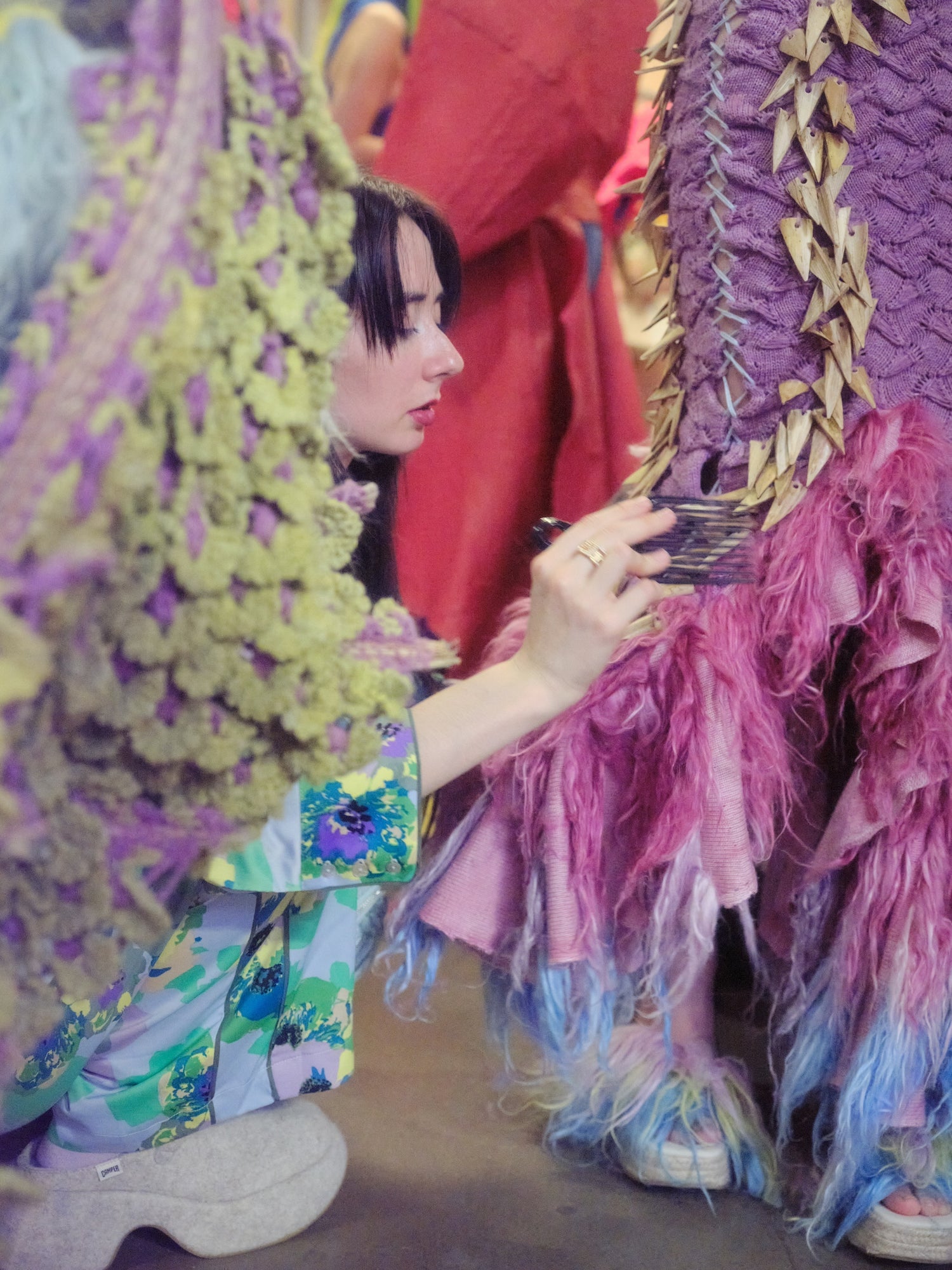 Founder Silvia Acien backstage at the Central Saint Martins press catwalk show, brushing the fur at the bottom of Look 3, TABERNAS.